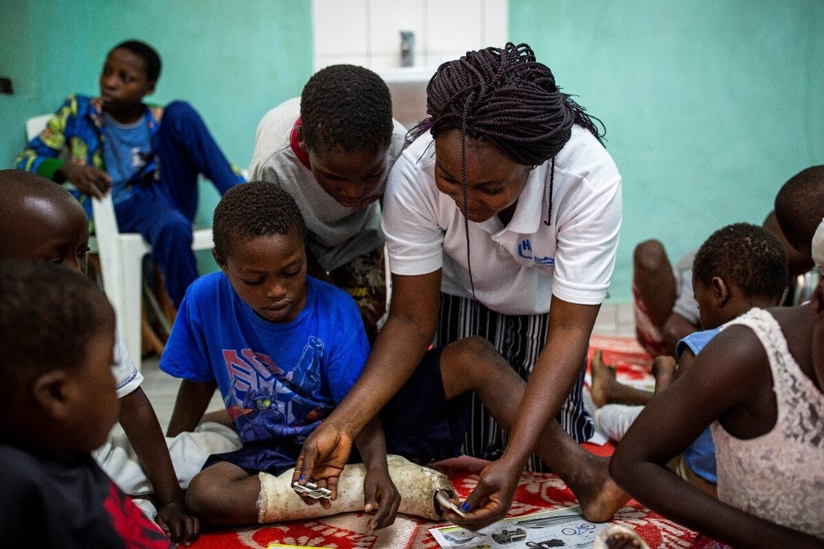 S&eacute;ance de soutien psychosocial &agrave; l'h&ocirc;pital de Rutshuru, au Nord Kivu, anim&eacute;e par Jonathan, le psychologue de HI. Kelvine et Kisubizo, deux petites filles amput&eacute;es apr&egrave;s avoir &eacute;t&eacute; bless&eacute;es &agrave; la jambe (affrontements rebelles), participent activement. Sur la photo la psychologue Brigiete Omba. Photo: &copy; Patrick Meinhardt / HI