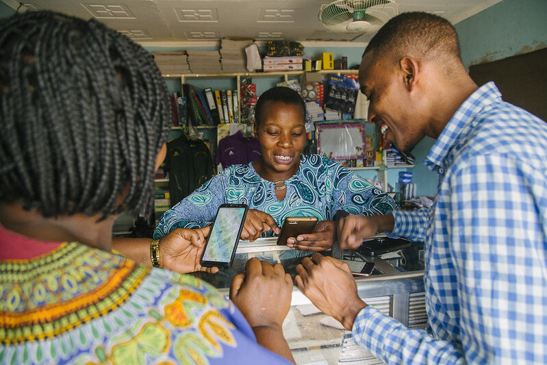 December 14, 2018: Mugumu, Tanzania: Geoffrey Katerrega, [right] a trainer from the NGO Humanitarian OpenStreetMap Team (HOT) and Rhobi Samwelly, [left] the director of the Hope Center Mugumu Safe House, train villagers from the northern Serengeti District of Tanzania on how to add data to the free, crowdsourced OpenStreetMap. These entries, such as names of roads, schools, shops, churches, and other points of interest, are helping create the first ever digital map of this part of Tanzania that can be used by citizens for an array of purposes. One crucial way the maps are being used are to help locate girls at risk of female genital mutilation, or FGM, which, though illegal, is still traditionally practiced in communities throughout the Serengeti. Photo: Global Devlab/ Photo by Bobby Neptune for DAI/flickr, CC BY-NC 2.0<br>