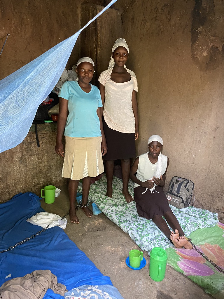 Two women are chained in a room at the Coptic Church Mamboleo, in Kisumu city, western Kenya, where over 60 men, women, and children with psychosocial disabilities are detained. They have to go to the toilet in front of each other, in a bucket in the room. Photo: &copy; 2020 Kriti Sharma/Human Rights Watch <br>