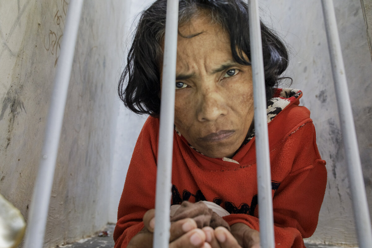 "A woman with a psychosocial disability lives confined in a bare narrow cell at madrasah Ar-Ridwan, a private Islamic healing center in Cilacap, Central Java, Indonesia. Photo: &copy; 2019 Andrea Star Reese