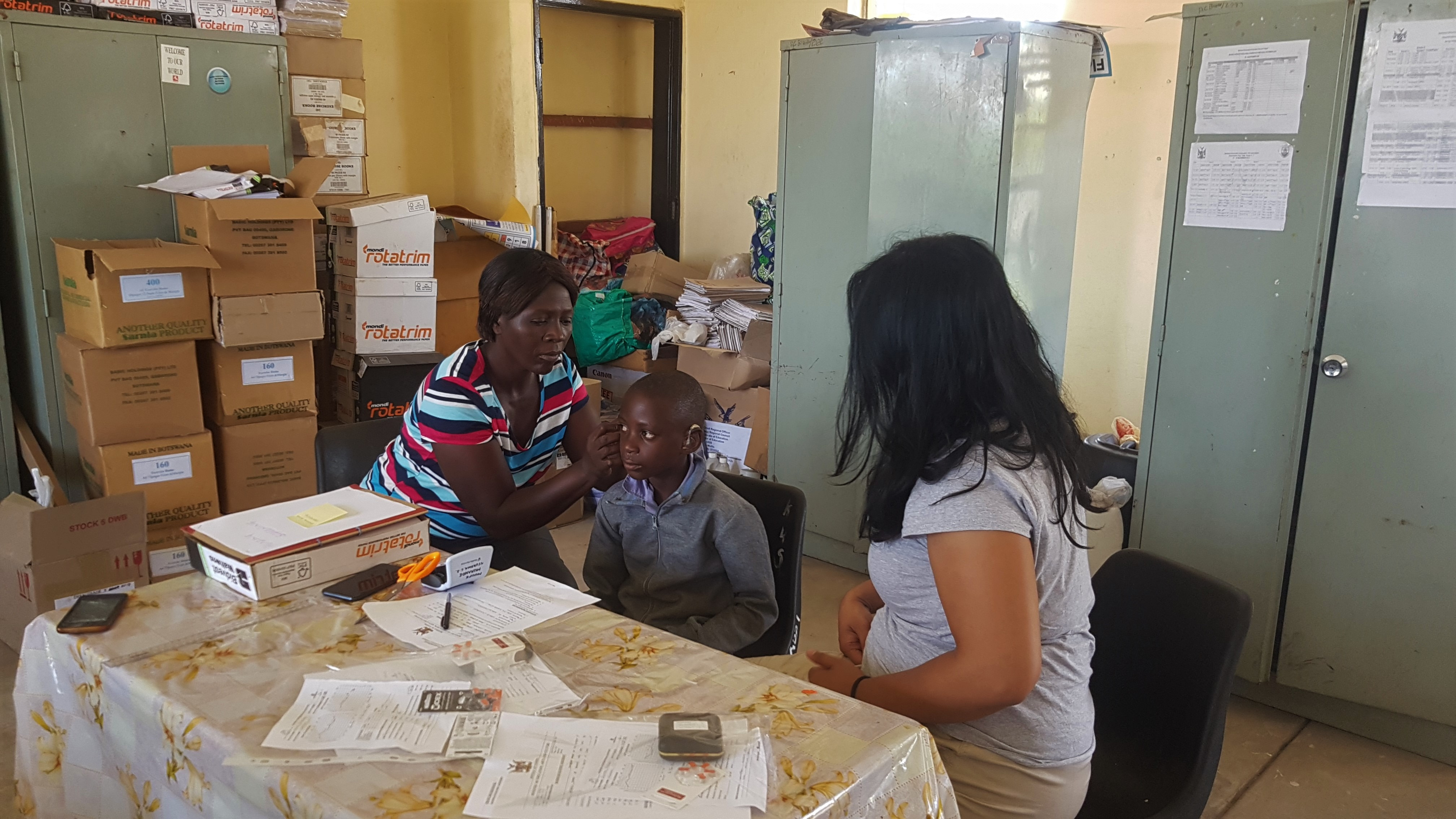 Die Mutter von Mukande setzt ihm die beiden H&ouml;rger&auml;te ein. Foto: &copy; Regula K&auml;ser<br>