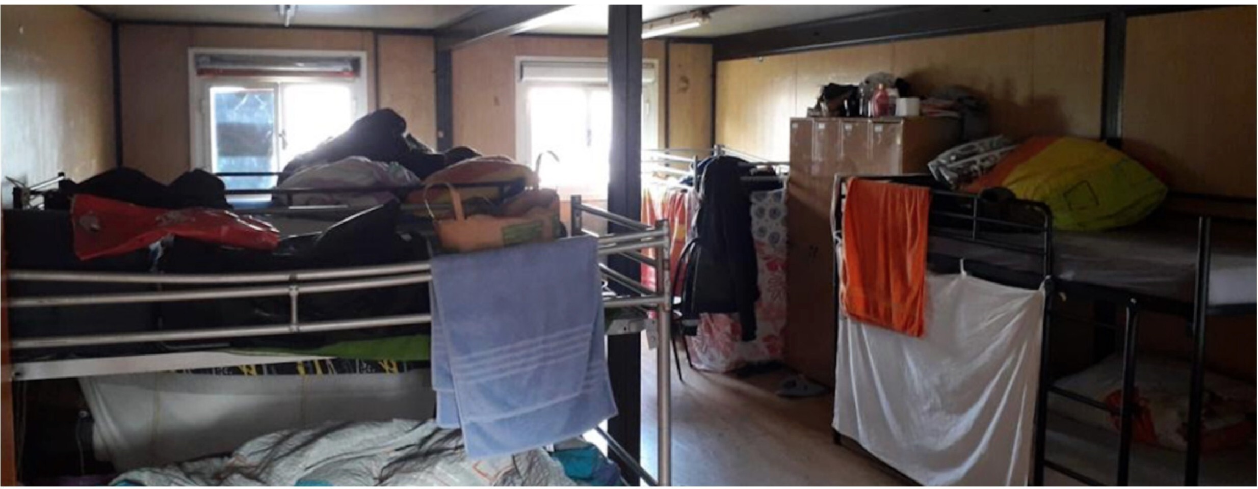 Dix personnes entass&eacute;es dans un espace restreint. "Salle de s&eacute;jour" dans un abri d'urgence zurichois. Photo: &copy; Ursula Markus<br>